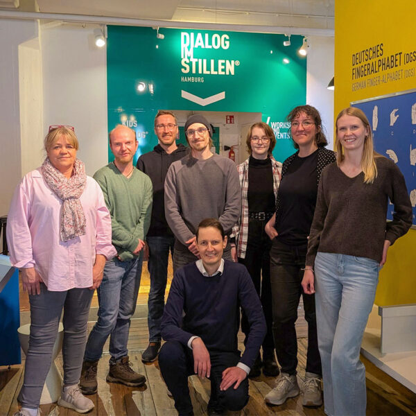 Teamfoto vor Ort am Eingang zur Ausstellung "Dialog im Stillen"