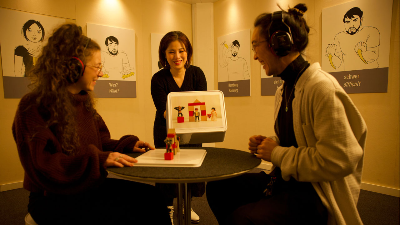 Pressefoto des Dialoghauses: Zwei junge Frauen versuchen sich an der Station mit dem Bauklotz-Spiel.